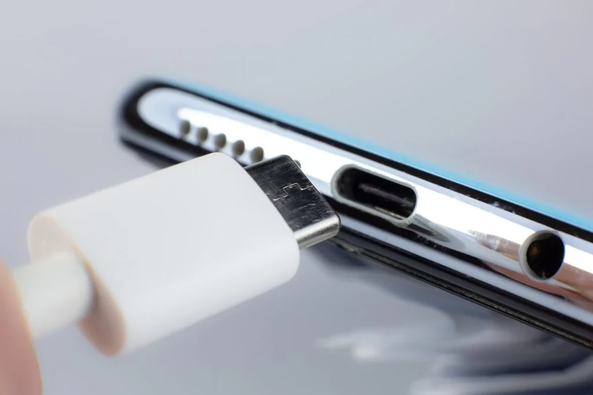 iPhone 14 Pro Max wallet case with MagSafe on a desk beside cards and a charger