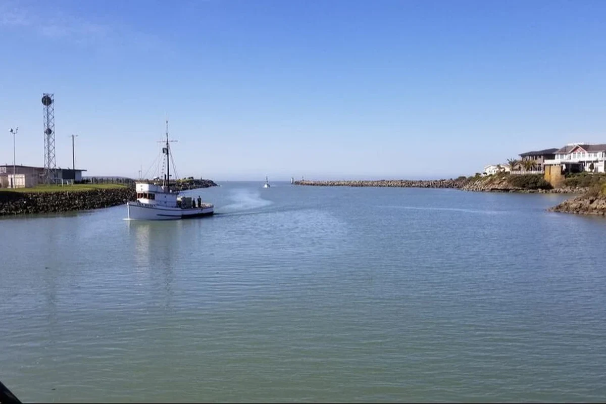 Live view of the Chetco River bar with surf, shoreline, and coastal weather conditions