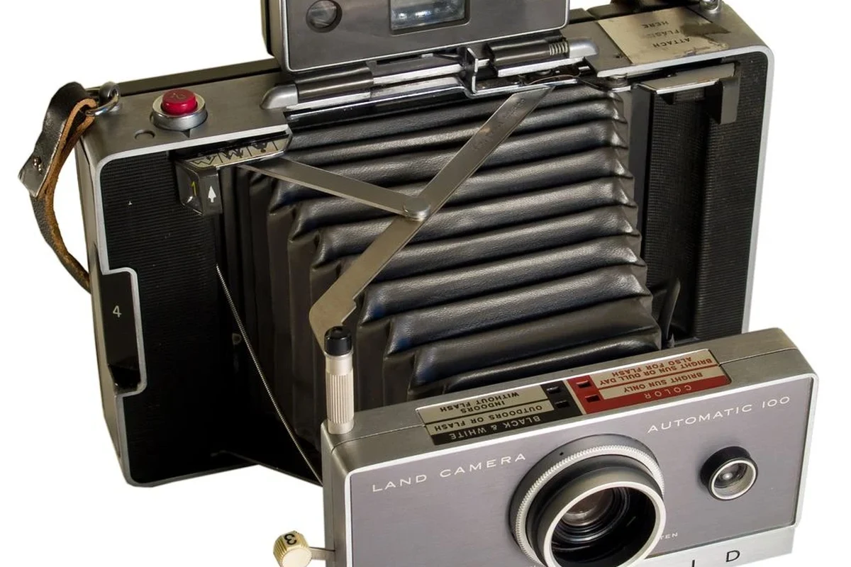 Vintage early Polaroid camera on a tabletop with instant film and soft studio lighting