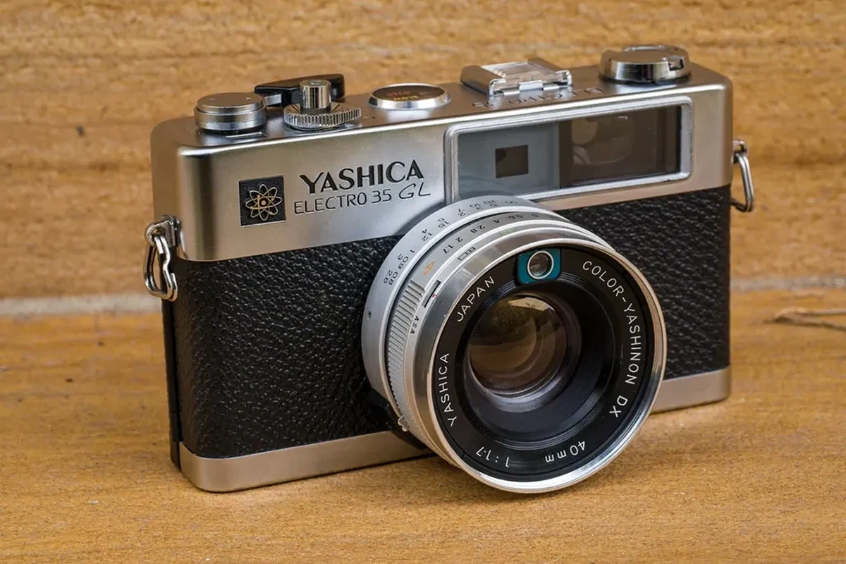 Vintage Yashica Electro 35 rangefinder camera on a clean tabletop with film photography accessories