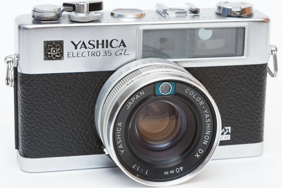 Vintage Yashica Electro 35 rangefinder camera on a clean tabletop with film photography accessories