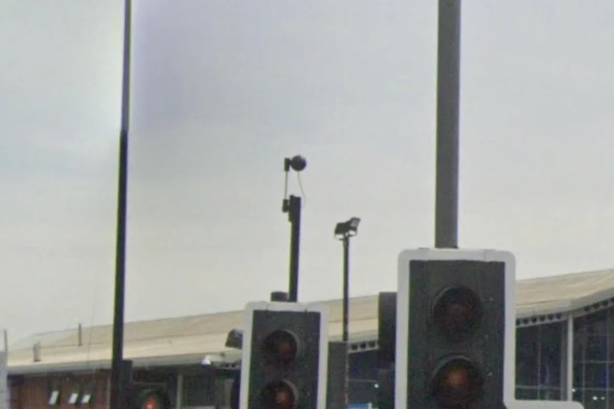 Traffic light at an intersection with roadside sensor hardware and no visible camera lens