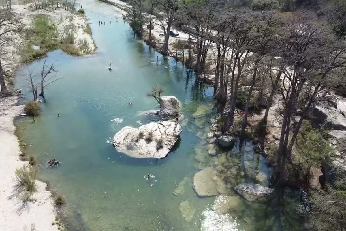 Live webcam view of the Frio River with calm water and scenic riverbank surroundings