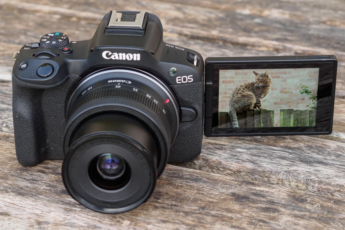 Beginner-friendly mirrorless camera with lens on a clean desk beside memory cards and accessories