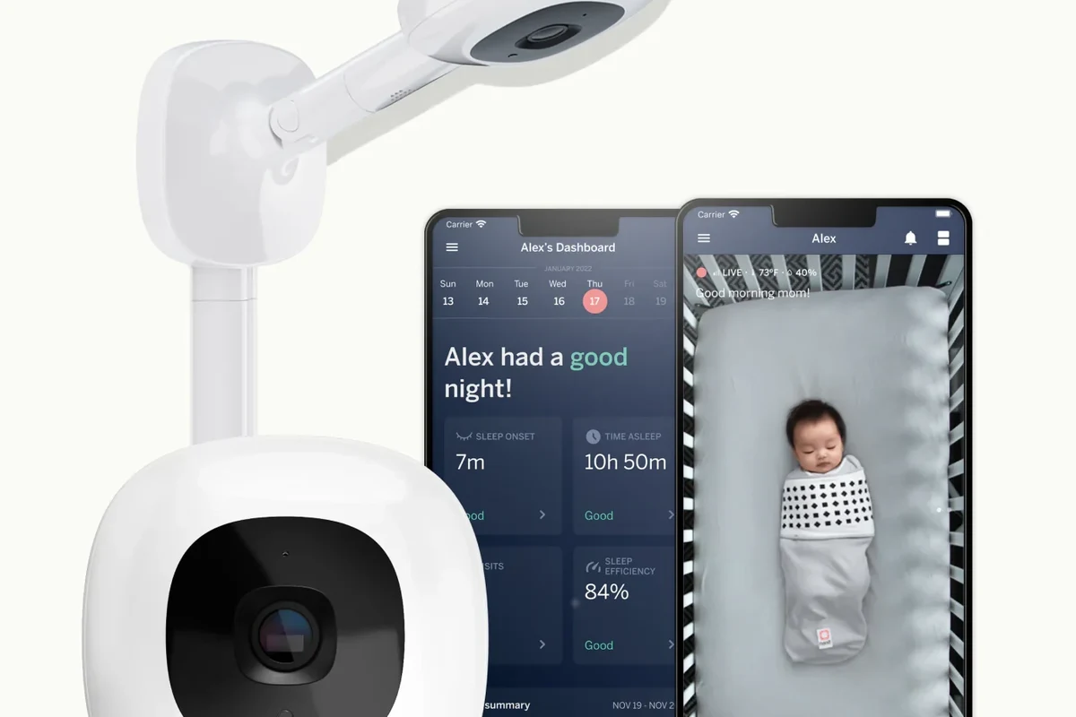 Smart nursery camera mounted above a crib showing a baby monitor app on a phone