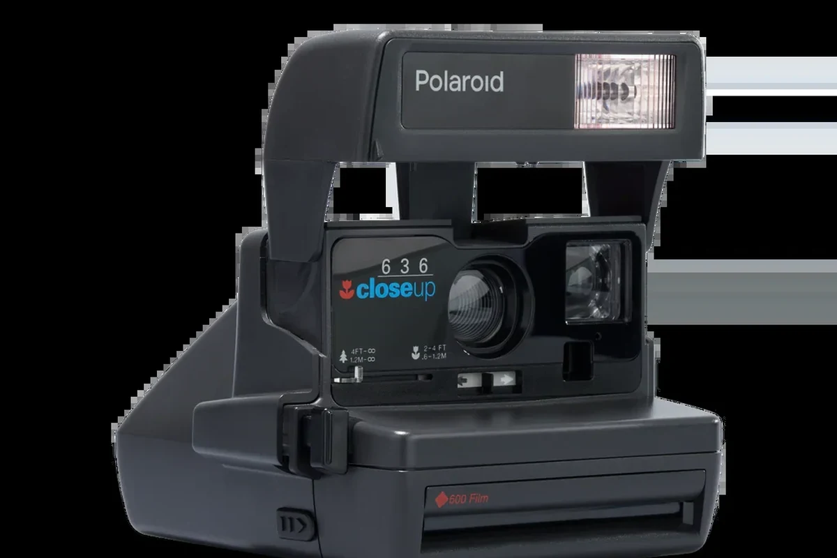 Polaroid OneStep Close Up instant camera on a clean tabletop with film and soft lighting