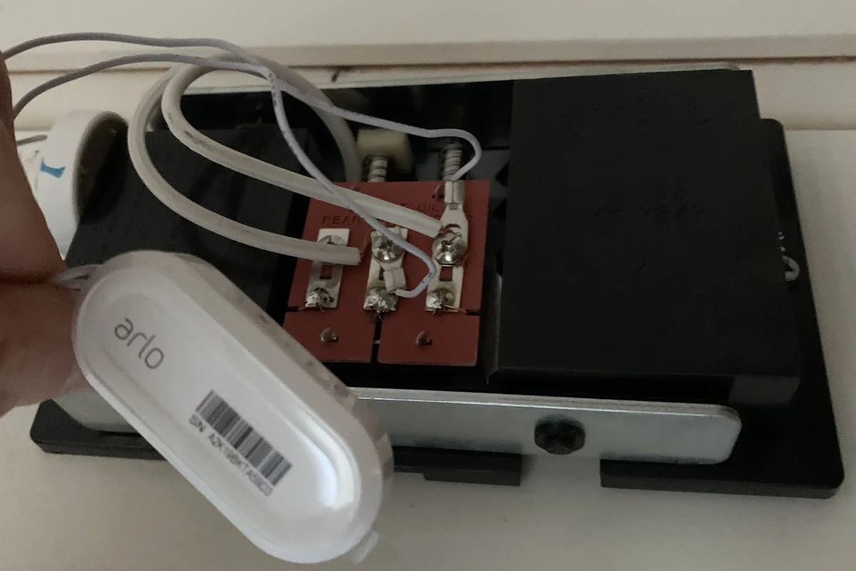 Arlo video doorbell mounted on a home exterior with wiring and battery setup context