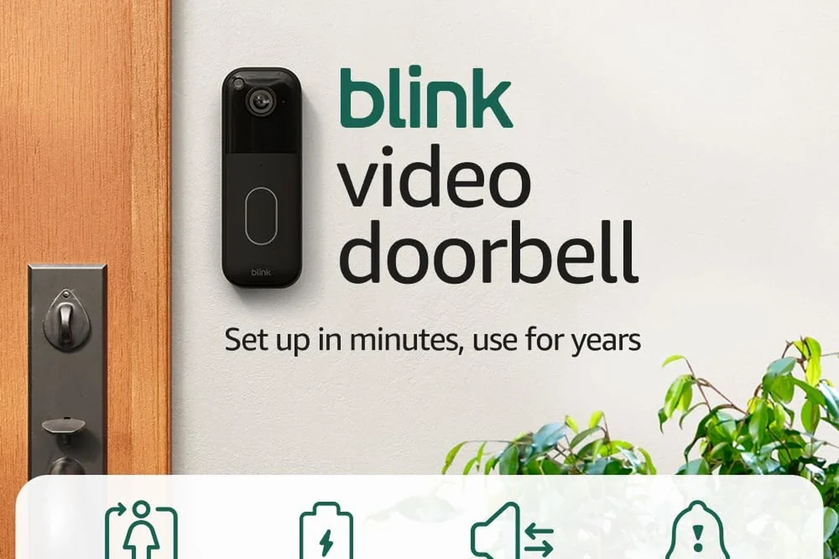 Blink video doorbell mounted by a front door with a smartphone showing the companion app