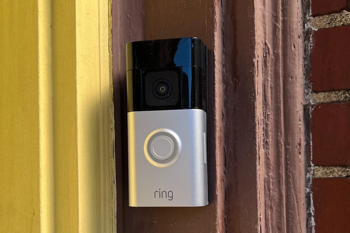 Ring video doorbell displayed near a home entryway with a smartphone app