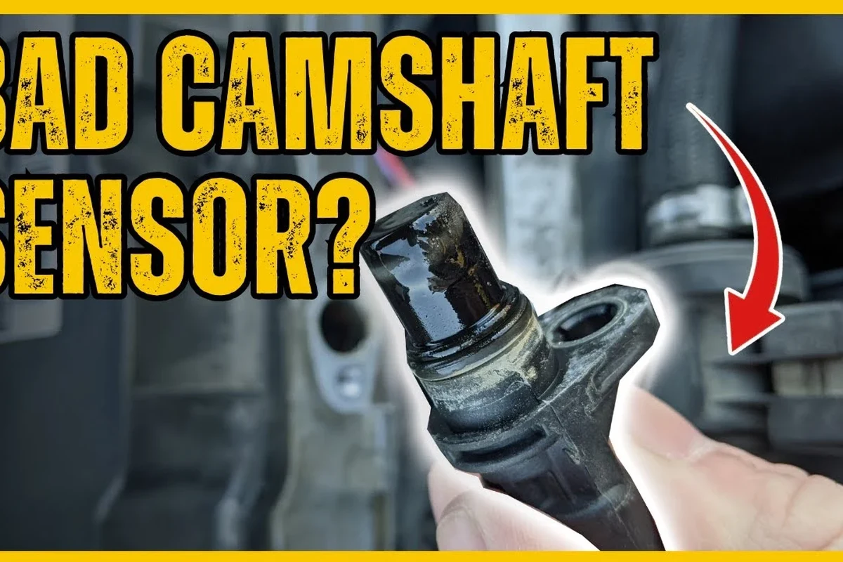 Mechanic-style close-up of a camshaft position sensor near an engine wiring harness