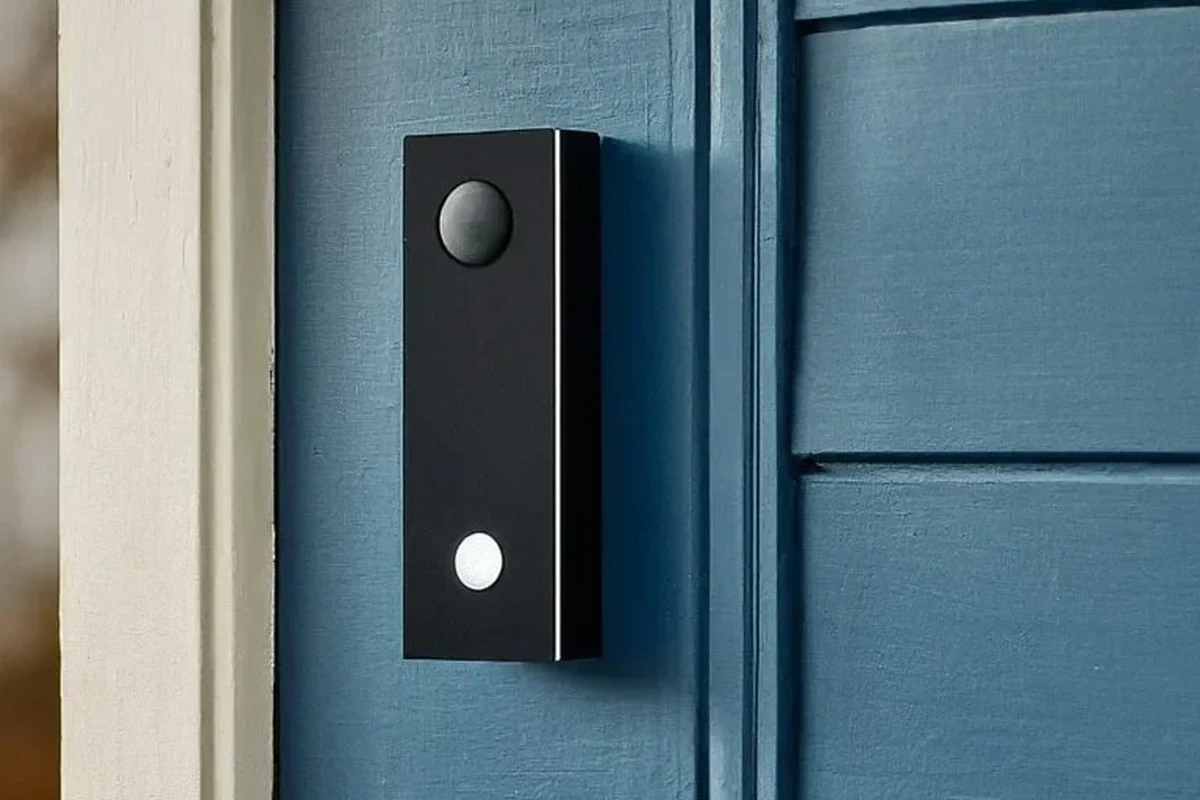 Video doorbell mounted beside a front door with a smartphone showing the camera feed