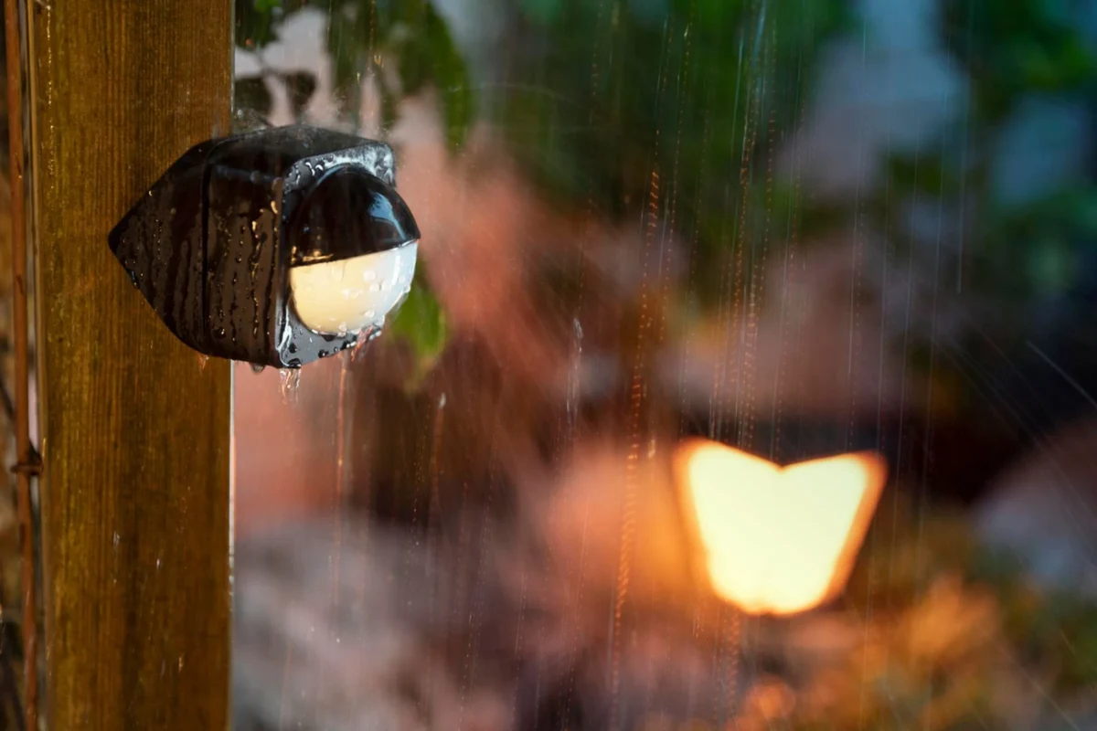 Outdoor motion sensor mounted under a porch overhang during rainy weather