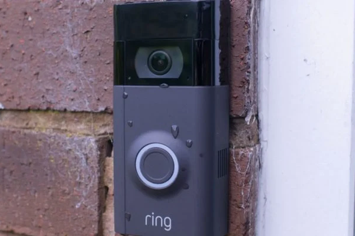 Ring video doorbell mounted outdoors under a porch during rainy weather