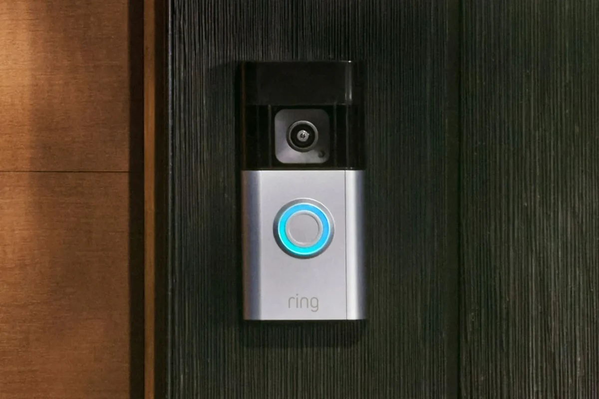 Ring video doorbell mounted at a front door with a smartphone showing live view