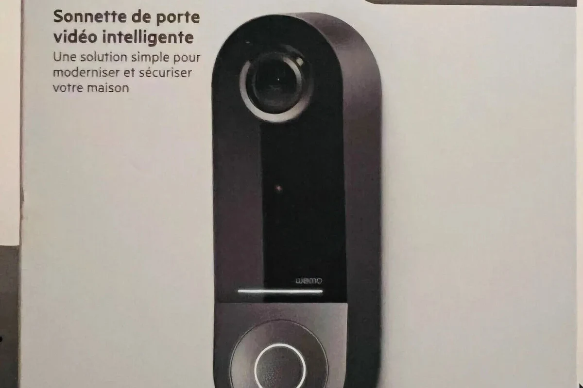 Apple HomeKit compatible video doorbell mounted at a front door with a smartphone nearby