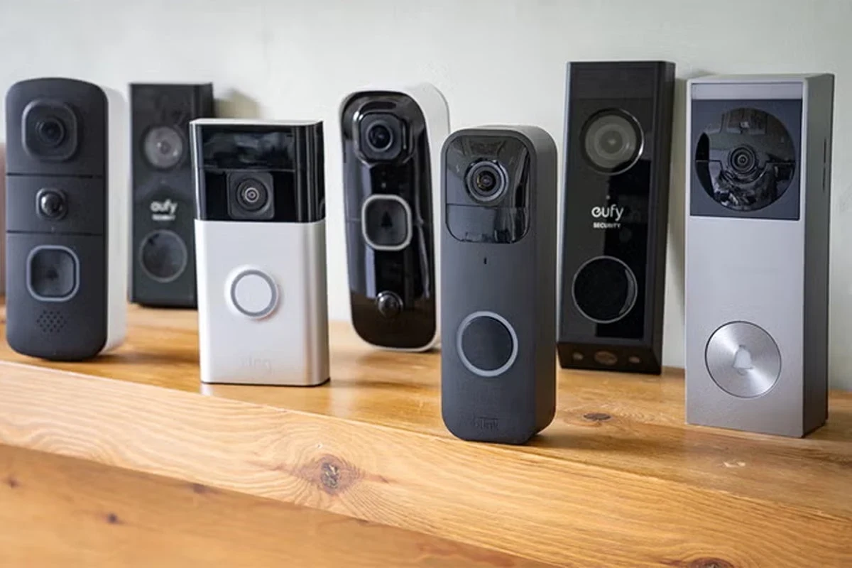 HomeKit-compatible video doorbell mounted beside a front door with a smartphone showing Apple Home
