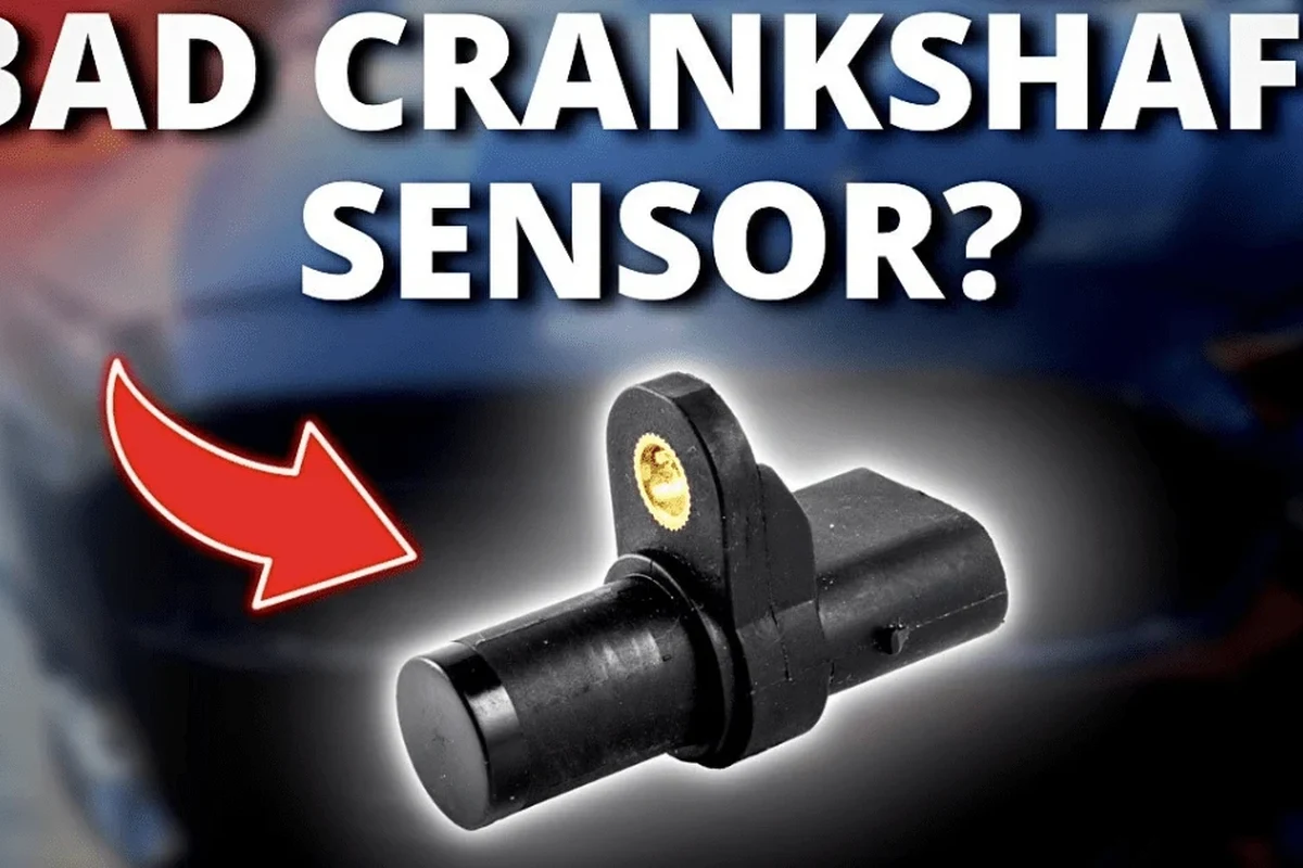 Mechanic inspecting a crankshaft sensor connector for water damage and corrosion in an engine bay