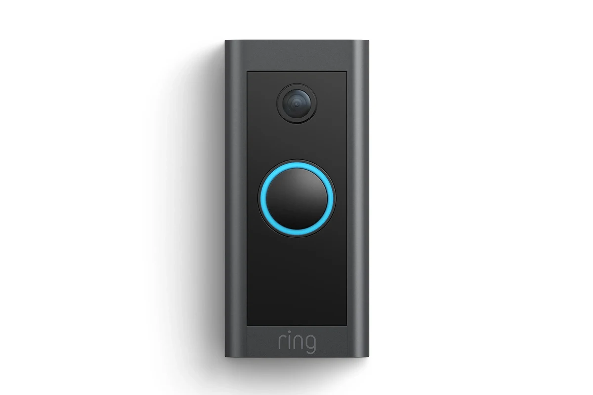 Wired video doorbell mounted beside a front door with home entryway background
