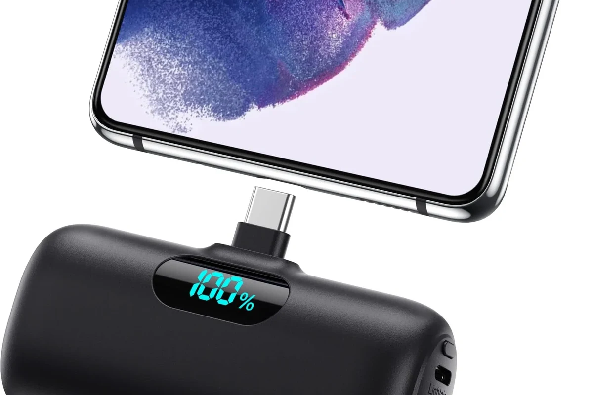 USB-C charging cable coiled beside a laptop, tablet, and power bank on a clean desk