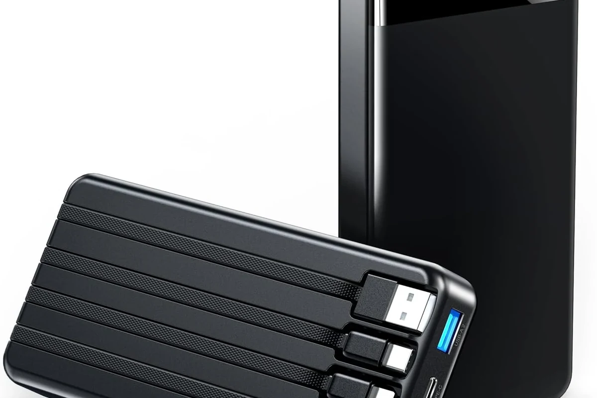 USB-C charging cable coiled beside a laptop, tablet, and power bank on a clean desk